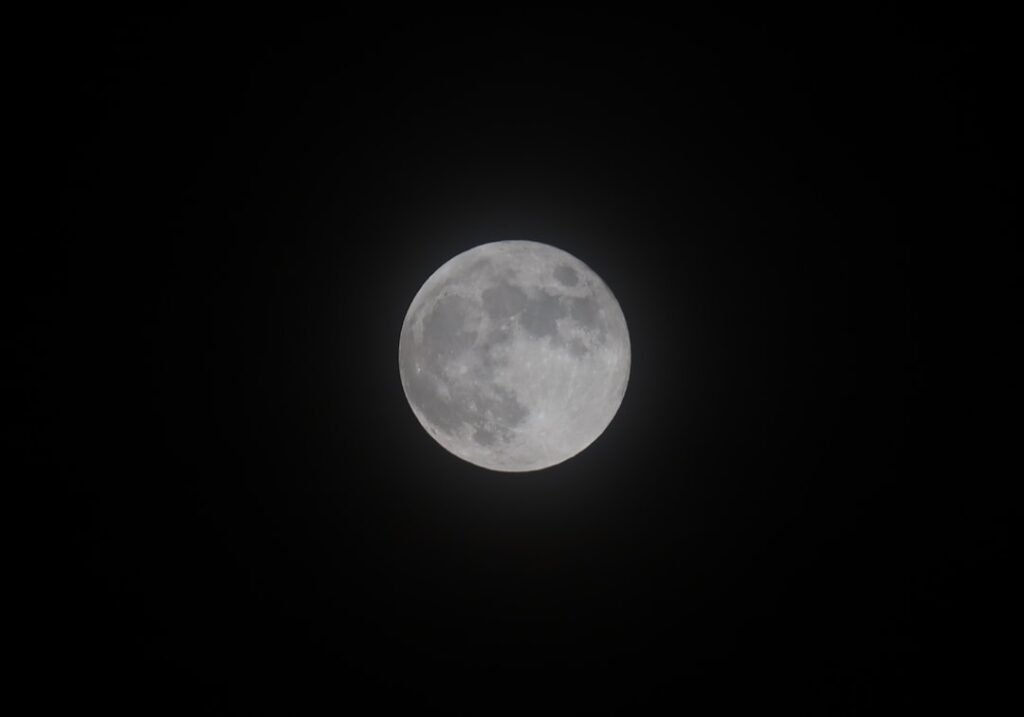 Moon glowing in a dark night sky, representing shadow work prompts for beginners